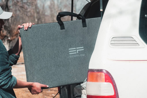 Portable EcoFlow power station being unloaded from an SUV, ideal for outdoor activities and emergency backup, showcasing compact design and mobility for reliable energy on the go.